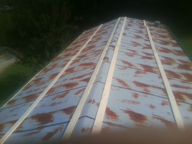 Rusted metal roof panels with new wood purlins before replacement — Storm Damage Roof Repair in Findlay by Roofing Brothers