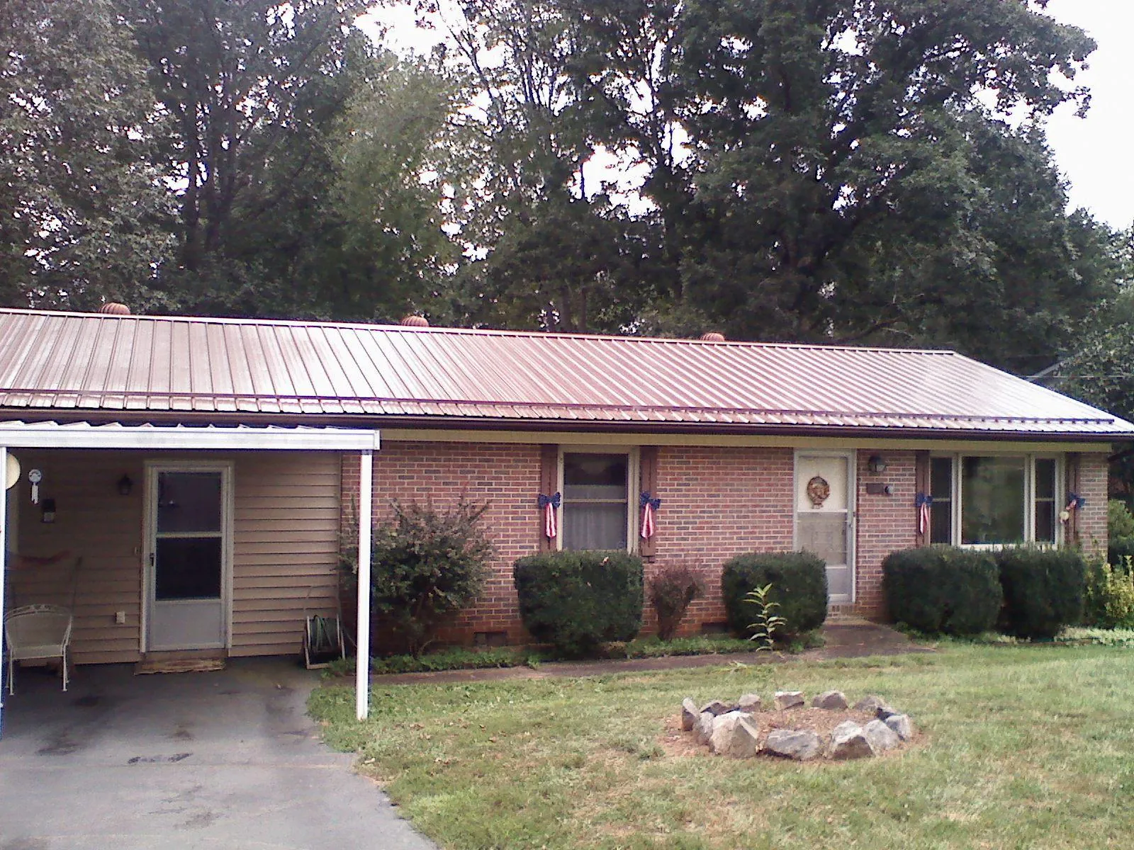 Bronze metal roof and carport on a brick ranch home — Roof Repair work by our crew in Findlay